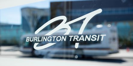 Burlington Transit logo on glass bus shelter wall.
